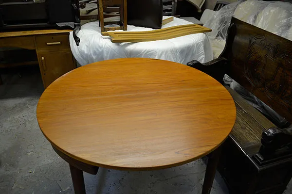 The same round dining table after re-finishing, its top an even golden brown