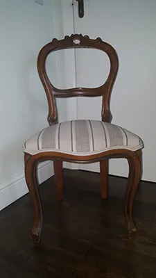 A dining chair re-upholstered in a striped fabric